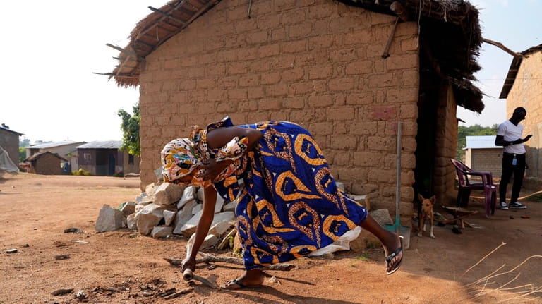 Carole, a 32-year-old former combatant, cleans outside her home in...