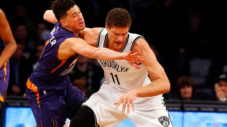 Brook Lopez, #11, of the Brooklyn Nets battles for the...