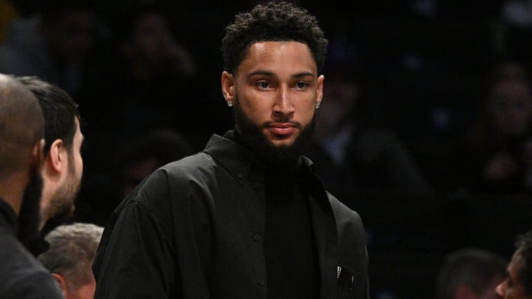 Nets guard Ben Simmons looks on before a game between...