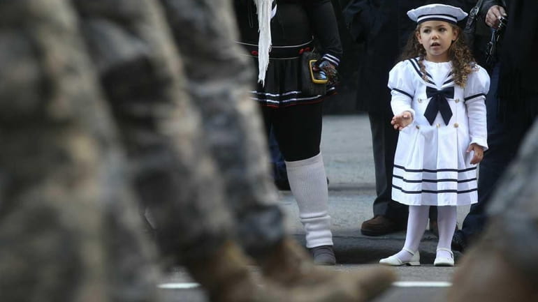 Gianna Piccolo, 3, whose father is a Navy veteran, watches...