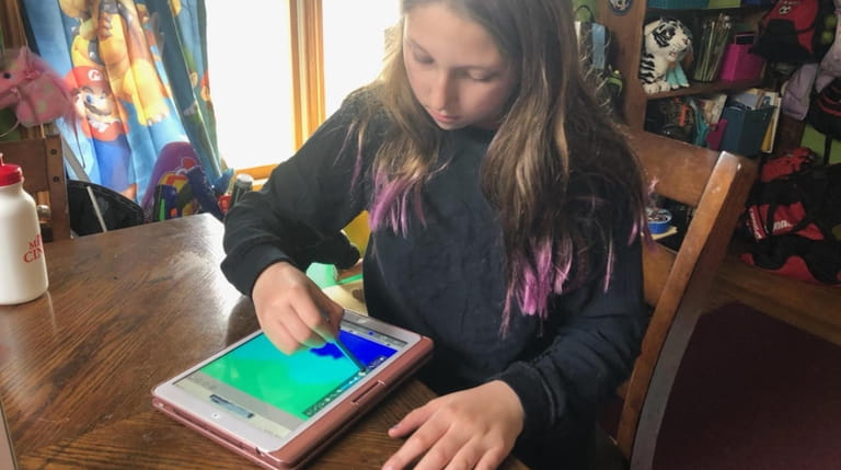 Skylar Kane, 10, of Massapequa, creates invitations on an iPad...