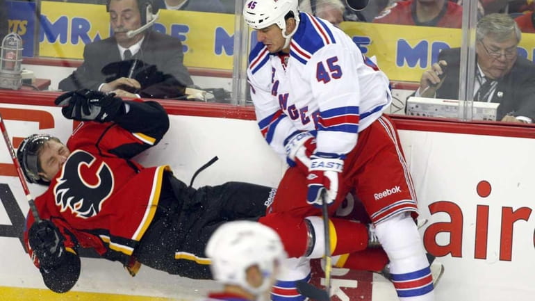 New York Rangers' Kris Newbury, right, sends Calgary Flames' Derek...