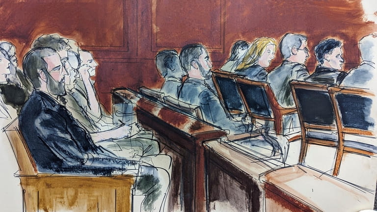 This courtroom sketch shows Samuel Bankman Fried, seated second from...