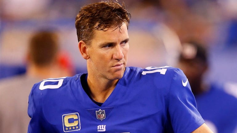 Eli Manning of the Giants looks on from the sidelines...