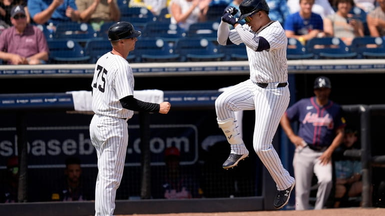 Yankees' Juan Soto celebrates with third base coach Travis Chapman,...