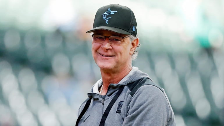 FILE - Then-Miami Marlins manager Don Mattingly smiles after throwing...
