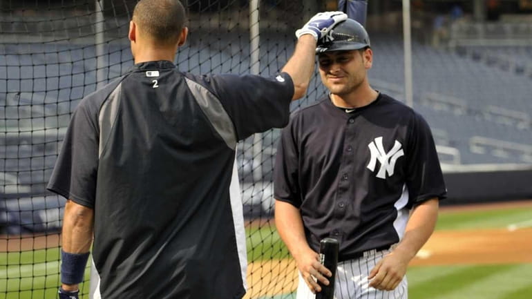 Derek Jeter, left, gives a pat on the head to...