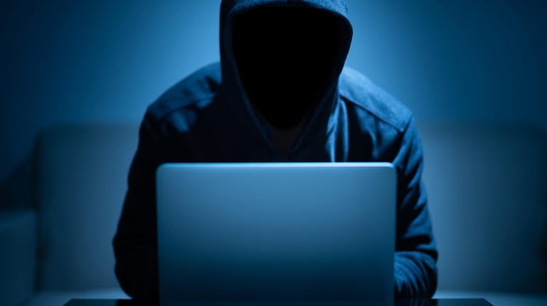 Hacker dark face using laptop in the dark room