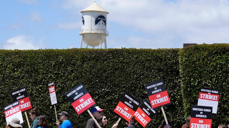 Striking writers take part in a rally in front of...