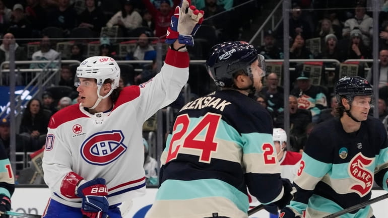 Montreal Canadiens left wing Juraj Slafkovsky, left, reacts to the...