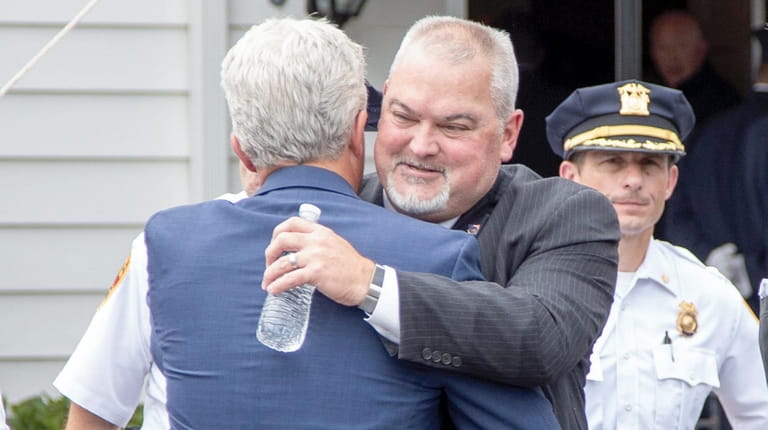 Suffolk County Executive Steve Bellone consoles Phillip Alvarez, center, brother...