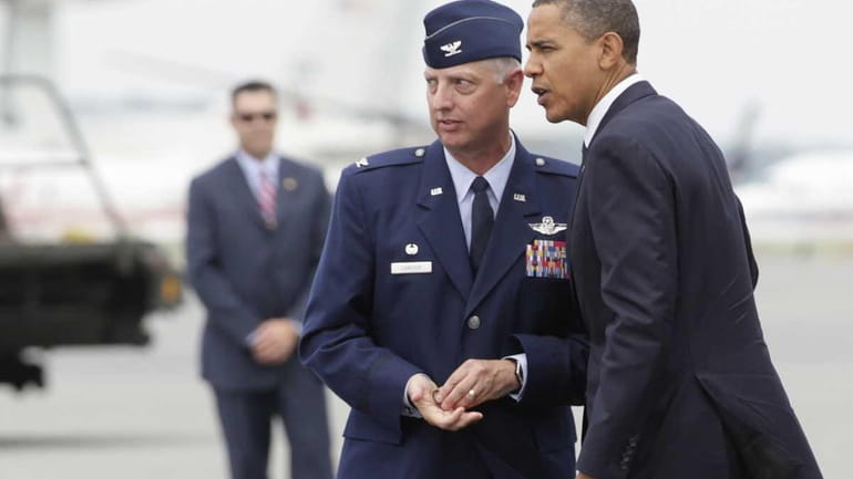 President Barack Obama is greeted by Col. Mark Camerer upon...