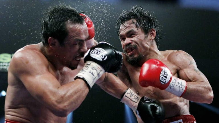Manny Pacquiao, right, of the Philippines, hits Mexico's Juan Manuel...