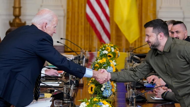 President Joe Biden shakes hands with Ukrainian President Volodymyr Zelenskyy...