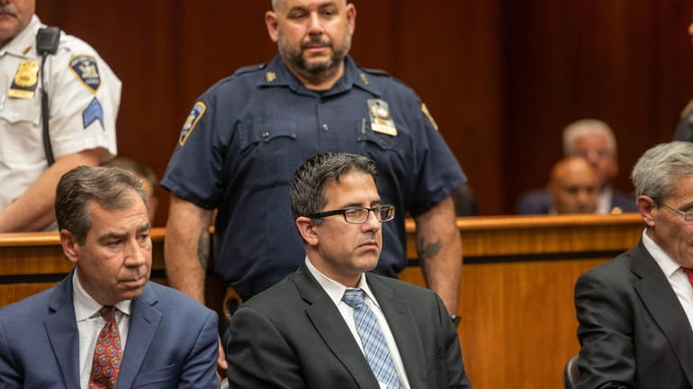 Former NYPD Officer Michael Valva, middle, listens to court proceedings...