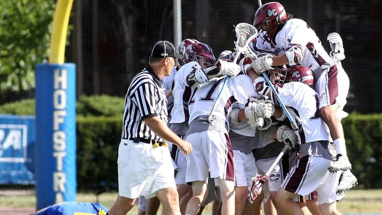 Garden City's boys lacrosse team celebrates their victory over Comsewogue...
