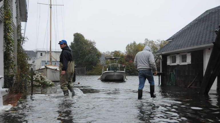 Owners check on their boats along Willow Street in Babylon...