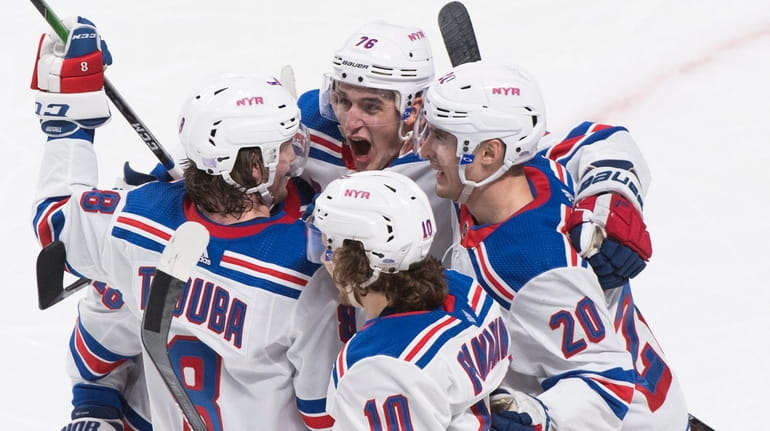 The Rangers' Jacob Trouba celebrates with teammates Brady Skjei, Chris Kreider and...