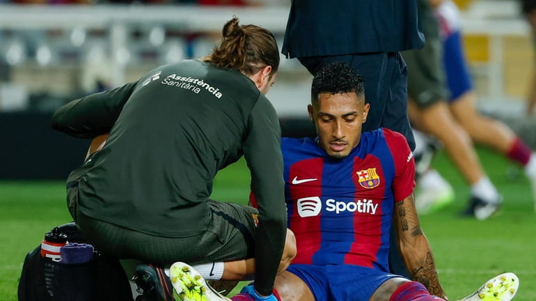 Barcelona's Raphinha receives medical treatment during a Spanish La Liga...