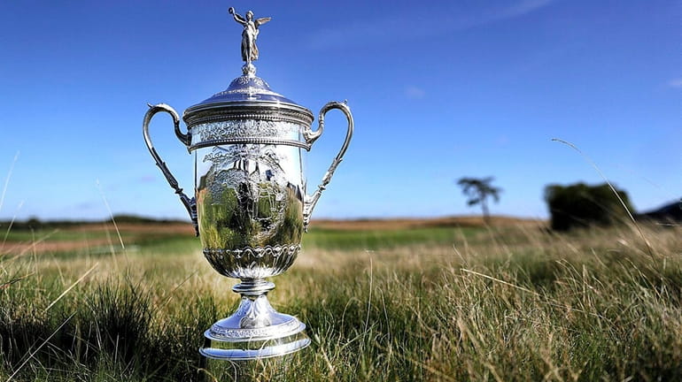 The U.S. Open trophy in the fescue beside the third...
