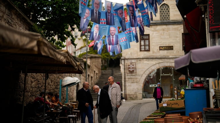People talk next to election banners of Turkish CHP party...