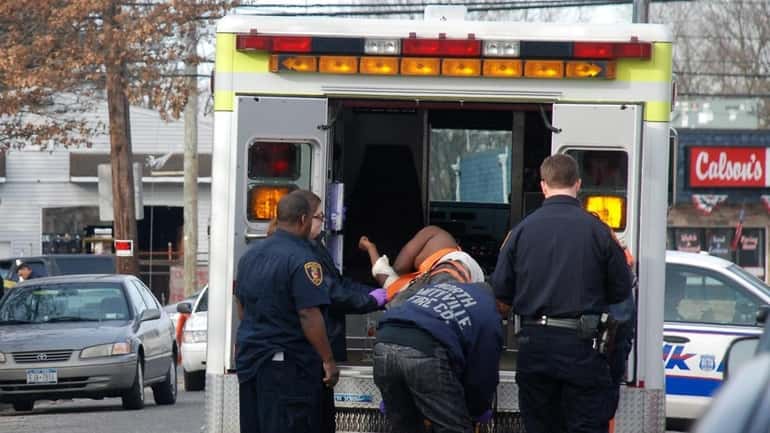 A male shooting victim is put into an ambulance on...
