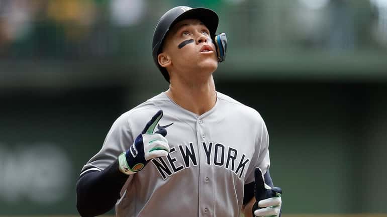 Aaron Judge #99 of the Yankees crosses home plate after hitting...