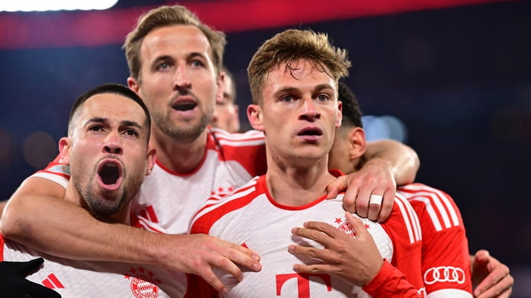 Bayern's Joshua Kimmich, right, celebrates with teammates after scoring his...