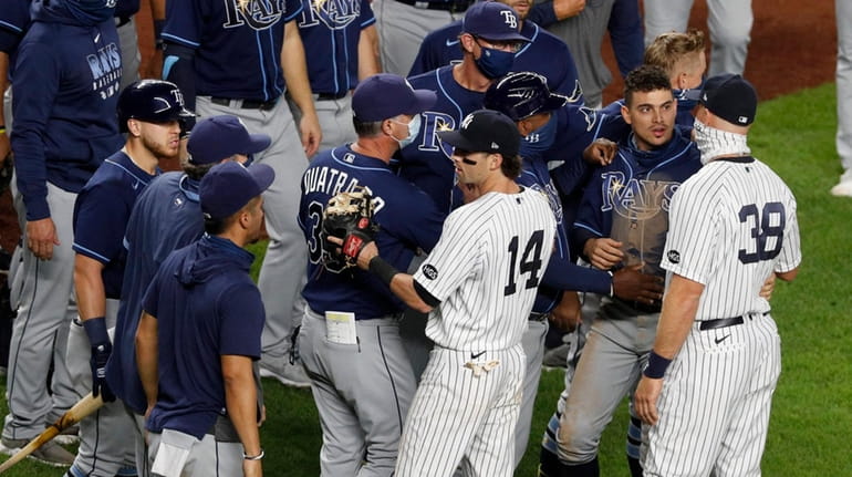 Tyler Wade and Erik Kratz of the Yankees try to...