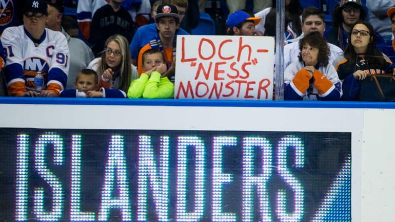 Islanders fans hold up signs before a preseason game against...