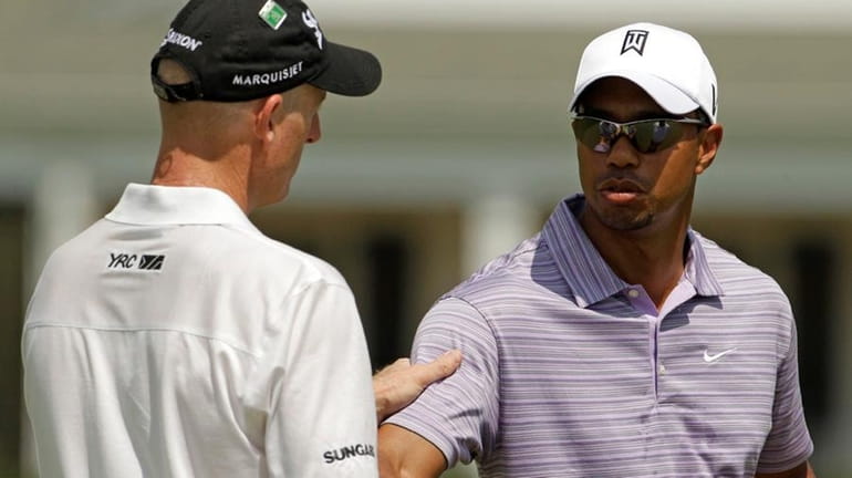 Tiger Woods shakes hands with golfer Jim Furyk. (April 4,...