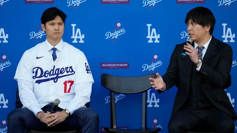 Los Angeles Dodgers' Shohei Ohtani, left, and interpreter Ippei Mizuhara...