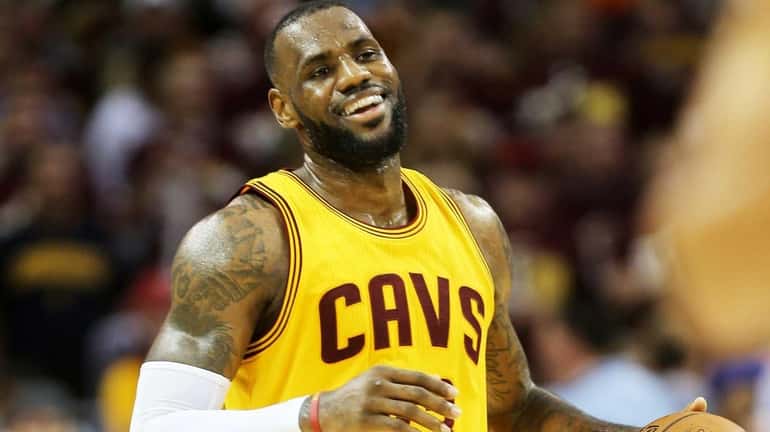 LeBron James of the Cleveland Cavaliers smiles in the third...