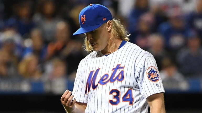 Mets pitcher Noah Syndergaard walks to the dugout after giving...