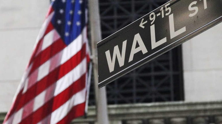 The sign for Wall Street is seen outside the New...