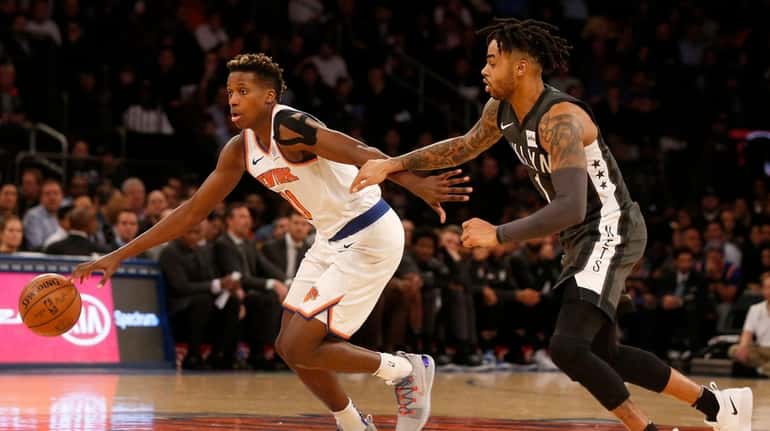 The Knicks' Frank Ntilikina drives past the Nets' D'Angelo Russell...