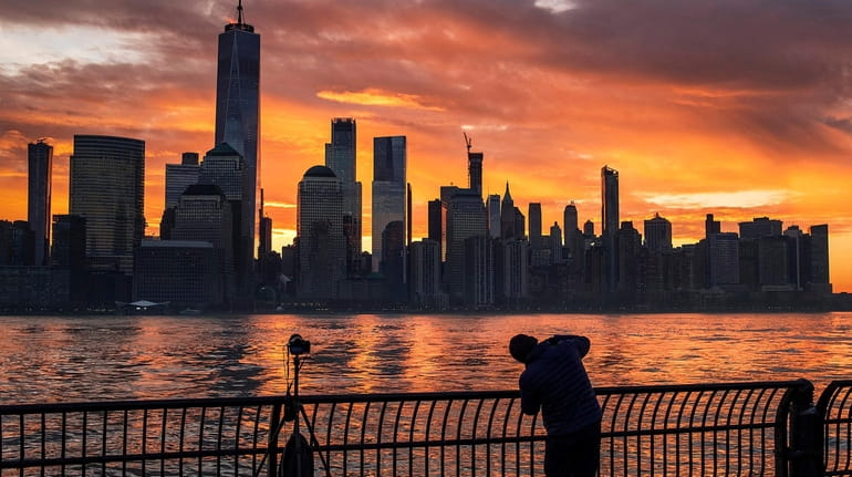 A photographer captures the sunrise behind the New York City...