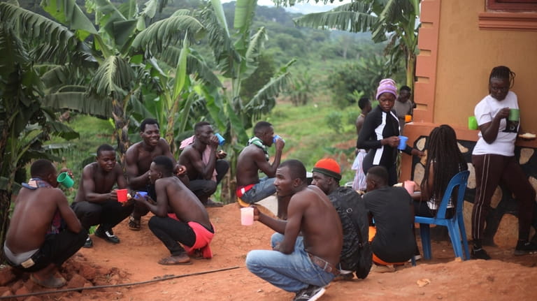 Ugandan youths have breakfast before an amateur wrestling tangle in...