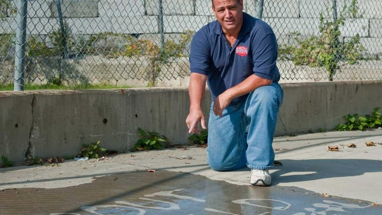 Michael Stracuzza shows off his grout seal on a sidewalk...