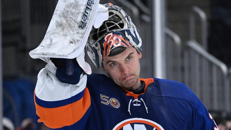 Islanders goaltender Ilya Sorokin adjusts his mask in the second...
