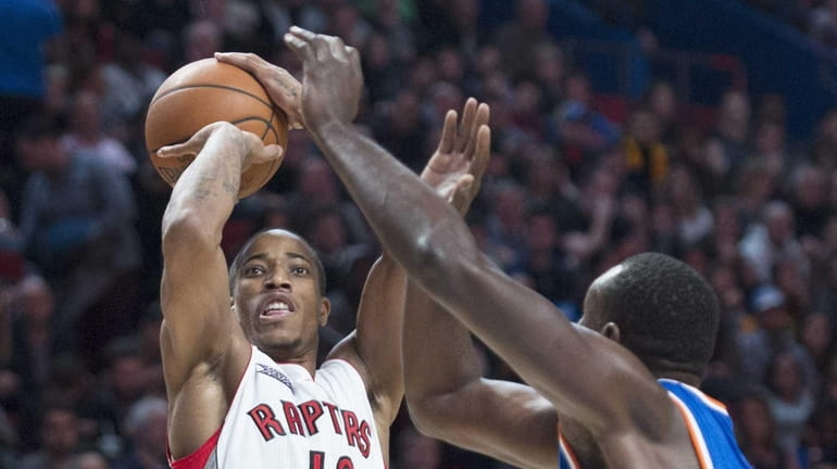 Toronto Raptors' DeMar DeRozan shoots as Knicks' Samuel Dalembert defends...