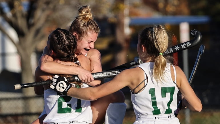 Mia Babino of Carle Place gets hugs from her teammates...