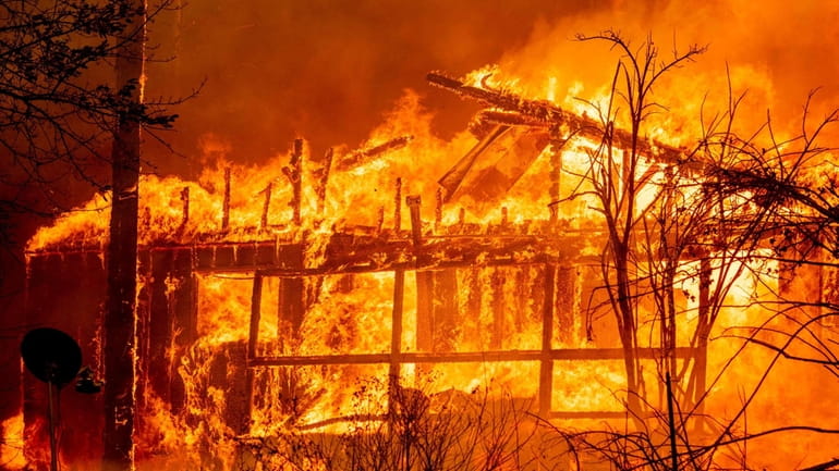 A home is engulfed in flames as the Dixie fire...