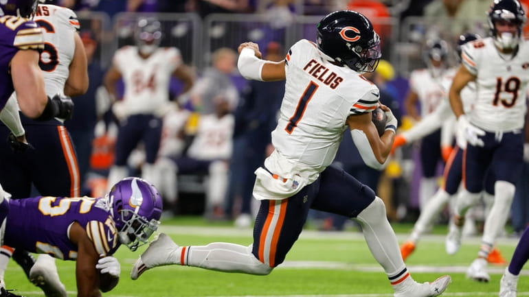 Chicago Bears quarterback Justin Fields (1) runs up field during...