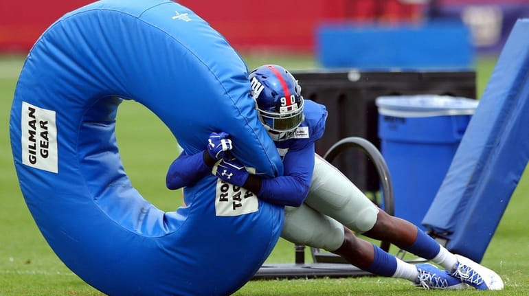Giants defensive end Jason Pierre-Paul hits a tackling donut during...