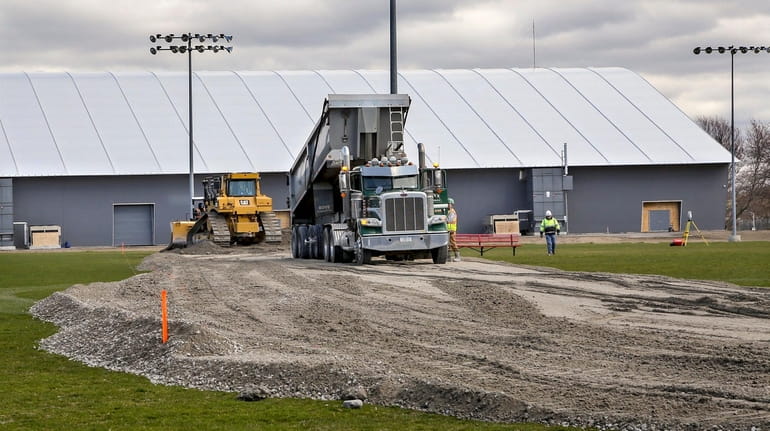 Workers build a road on Tuesday to access an athletic facility...