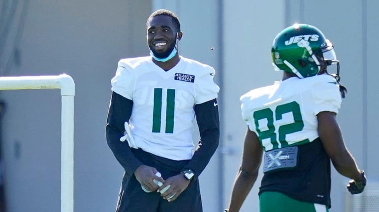 The Jets' Denzel Mims stand off to the side during a...