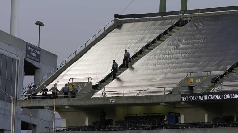Law enforcement officials walk in the upper deck of O.co...