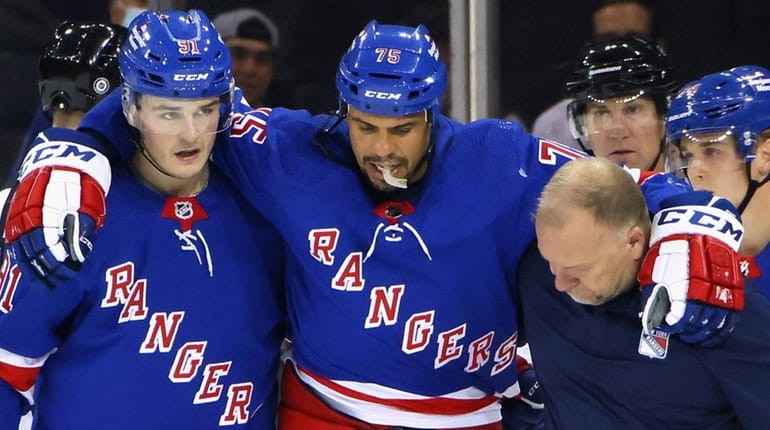 Ryan Reaves #75 of the Rangers is escorted off the ice following...