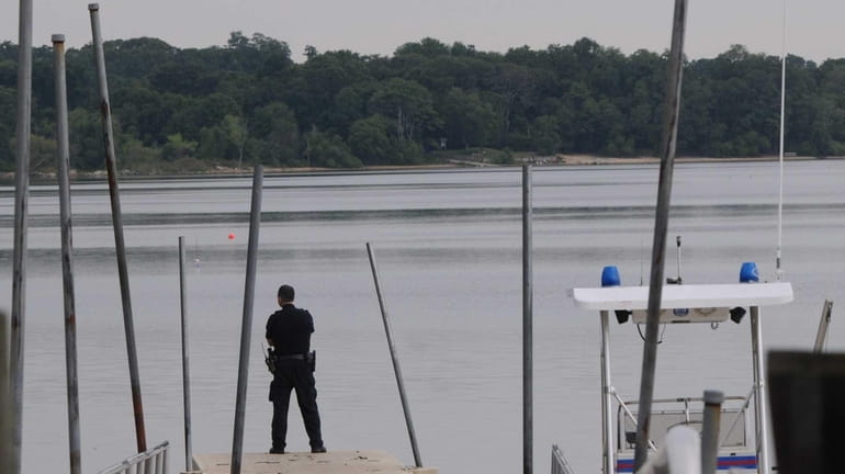 A Suffolk County police officer checks Lake Ronkonkoma Sunday morning...